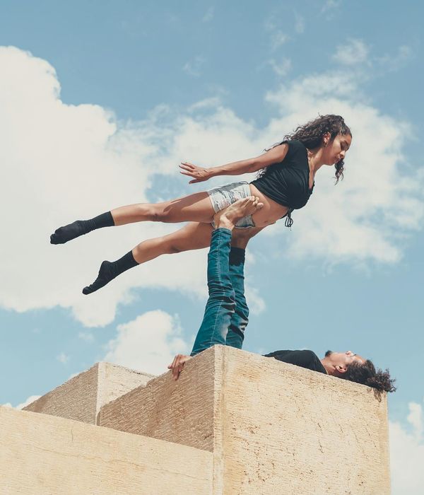 Man performing a controlled strength exercise in a minimalist dark room.
